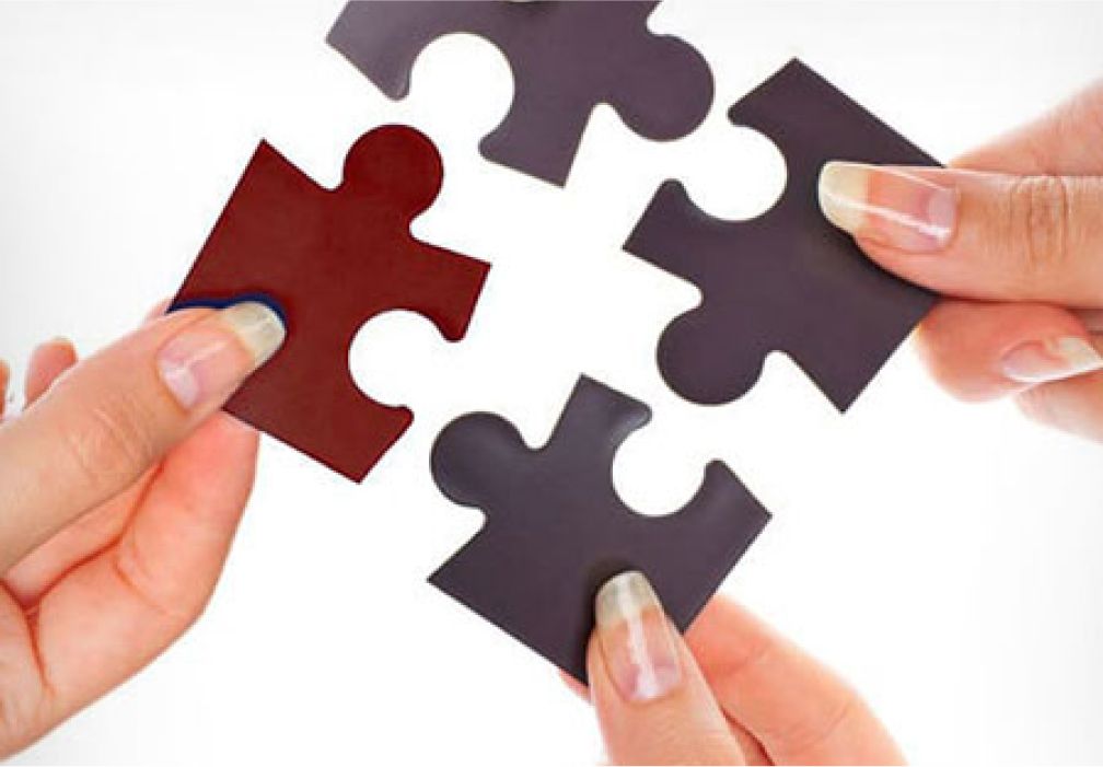 Unternehmen - Hände halten Puzzleteile